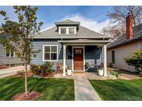 Charming blue home with a cozy front porch and well-manicured lawn at 3052 S Cherokee St, Englewood, CO 80110