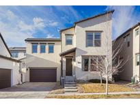 Charming two-story home featuring a modern design, attached garage, and well-maintained landscaping at 15579 W Harvard Ave, Lakewood, CO 80228