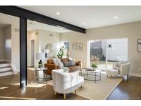 Bright living room features a leather sofa, armchairs, and large windows at 3932 Quivas St, Denver, CO 80211