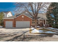 Charming brick home with a three-car garage, a well-manicured lawn, and mature trees, offering curb appeal and practicality at 2472 W Peakview Ct, Littleton, CO 80120