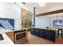 Bright kitchen featuring an indoor courtyard with a wooden accent wall and modern appliances at 6305 W 6Th Ave # C12, Lakewood, CO 80214