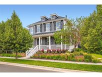 Charming two-story home with a welcoming front porch and professionally landscaped yard at 3597 Xanthia St, Denver, CO 80238