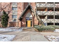 Striking brick building entrance featuring a unique A-frame design and well-maintained landscaping at 1243 Gaylord St # 302, Denver, CO 80206
