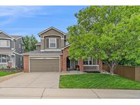 Charming two-story home with a well-manicured lawn, mature trees and a brick and siding facade at 3860 Mallard Dr, Highlands Ranch, CO 80126