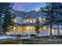 Stunning two-story home featuring a welcoming front porch and beautiful architectural details at 6857 Timbers Drive, Evergreen, CO 80439