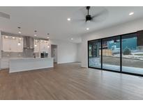 Bright, open-concept living space with hardwood floors and a modern kitchen and fireplace at 461 Muirfield Cir, Louisville, CO 80027