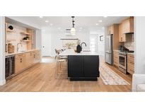Bright kitchen features a large island, stainless appliances, and light wood cabinets at 1757 W 36Th Ave, Denver, CO 80211