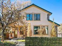 Charming two-story home with a stucco exterior, stone accents, a well-kept lawn, and a welcoming front porch at 2673 S Cook St, Denver, CO 80210