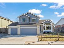 Charming two-story home with a three-car garage and blue siding, perfect for a Gathering at 908 Cinnamon Ln, Louisville, CO 80027