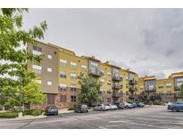 Condominium complex featuring yellow siding, brick accents, and balconies in a well-maintained community at 9019 E Panorama Cir # D504, Englewood, CO 80112
