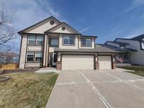 Charming two-story home with a three-car garage and manicured lawn on a beautiful sunny day at 106 Cherry St, Castle Rock, CO 80104