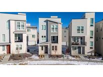 Modern three-story townhome with light brick exterior and balcony at 12374 Farmview St, Thornton, CO 80241