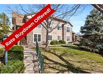 Attractive condo features lush lawn, mature trees, and stone accents for a charming curb appeal at 4084 S Crystal Cir # 104, Aurora, CO 80014