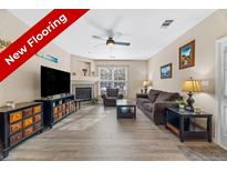 Inviting living room featuring new flooring, a cozy fireplace, and neutral decor at 4084 S Crystal Cir # 104, Aurora, CO 80014