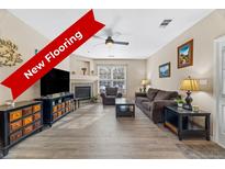 Inviting living room featuring new flooring, a fireplace, and neutral decor at 4084 S Crystal Cir # 104, Aurora, CO 80014