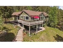 Beautiful two-story home with an inviting deck and lush landscaping at 20410 Brookmont Rd, Morrison, CO 80465