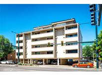Exterior view of condo building with parking garage, balconies and street access on a bright day at 1035 Colorado Blvd # 405, Denver, CO 80206