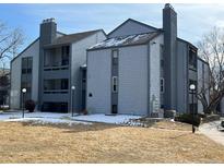 Multi-story condominium complex featuring a blue-gray exterior and chimney on a sunny day at 13962 E Stanford Cir # L07, Aurora, CO 80015