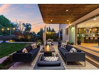Inviting outdoor patio featuring modern furniture, fire pit, string lights, and access to the home's stylish interior at 2658 Wolff St, Denver, CO 80212