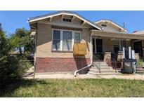 A brick two-story home features a combination brick and stone front and well maintained lawn at 1415 Raleigh St, Denver, CO 80204