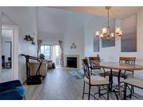 Cozy living room featuring a fireplace and hardwood floors, leading to a sunny balcony at 11115 E Alameda Ave # 201, Aurora, CO 80012