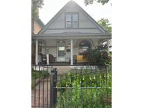 Charming home featuring a covered front porch with comfortable seating and a blossoming garden at 36 N Logan St, Denver, CO 80203