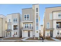Modern three-story townhouses with stone accents and attached garages at 5275 Queen Ct, Arvada, CO 80002