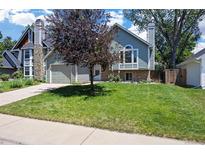 Charming two-story home with well-manicured lawn, mature tree, and attached two-car garage at 4786 S Yampa St, Aurora, CO 80015