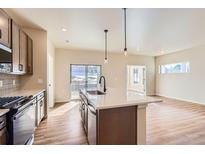 Modern kitchen features island, stainless steel appliances, and access to backyard patio at 804 W 128Th Pl, Westminster, CO 80234