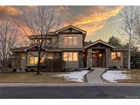 Beautiful two-story home featuring a stone facade, tasteful landscaping, and a warm, inviting entrance at 6928 S Eaton St, Littleton, CO 80128