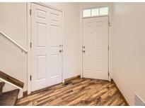 Inviting entryway with wood-look flooring and a front door with transom window and coat closet at 12265 E 2Nd Dr, Aurora, CO 80011