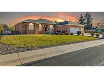 Brick ranch home with landscaped lawn and attached garage at 3810 Urban St, Wheat Ridge, CO 80033