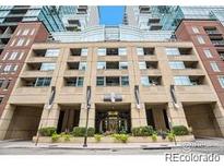 Multi-story building with brick facade, covered parking, and manicured landscaping on a sunny day at 1700 Bassett St # 1301, Denver, CO 80202