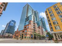 Contemporary condo building featuring a brick facade and glass windows against a blue sky backdrop at 1700 Bassett St # 1301, Denver, CO 80202