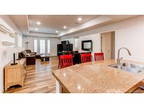 A kitchen island overlooks the living and dining areas of this open-concept home design at 2200 S University Blvd # 212, Denver, CO 80210