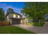 Charming gray two-story home featuring a well-manicured lawn, mature trees, and inviting curb appeal at 11035 E Berry Ave, Englewood, CO 80111