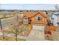 Charming two-story home with a large front yard, two car garage, and sidewalk leading up to the front door at 14425 E 50Th Ave, Denver, CO 80239