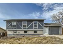 Two-story home features blue siding, brick accents, a white front door, and an attached garage at 9955 Fillmore St, Thornton, CO 80229