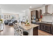 Modern kitchen with granite countertops, stainless steel appliances, and a view to the living room at 27593 E 1St Pl, Aurora, CO 80018