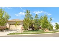 Charming front exterior with a manicured lawn, mature trees, and a beige two-car garage at 4519 Silver Mountain Loop, Broomfield, CO 80023