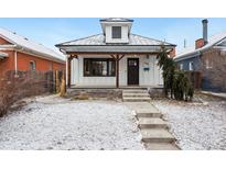 Charming home with a cozy front porch and snowy front yard, complete with inviting curb appeal at 1375 Perry St, Denver, CO 80204