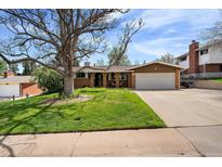 Charming ranch-style house with a two-car garage and a lush front yard with mature trees at 13464 W Virginia Dr, Lakewood, CO 80228
