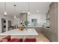 Modern kitchen with stainless steel appliances, a large island, and stylish pendant lighting creates a bright and welcoming space at 1401 Delgany St # 204, Denver, CO 80202