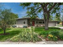 Charming gray single-story home featuring a lush front yard and manicured landscaping at 5 Hillside Dr, Wheat Ridge, CO 80215
