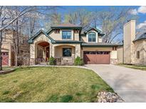 Traditional two-story home with a well-kept lawn, lush trees, and a wide driveway for easy parking at 2411 S Garfield St, Denver, CO 80210