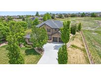 Stunning two-story home with lush landscaping, a concrete driveway, and a three-car garage at 14958 Wistera Way, Broomfield, CO 80023