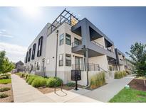 Modern condo building with balconies, clean lines and contemporary design under a bright sky at 2400 S Delaware St # 1, Denver, CO 80223