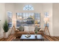 Bright living room with a large picture window, hardwood floors, and a comfortable leather sofa at 207 S Quicksilver Ave, Castle Rock, CO 80104