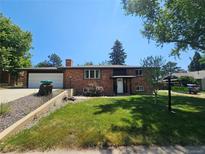 Charming brick home with a well-maintained lawn and mature trees in a quiet neighborhood at 6614 Everett St, Arvada, CO 80004