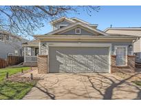 Exterior view of a two car garage with brick detail and an extended driveway at 20521 E Bellewood Pl, Aurora, CO 80015